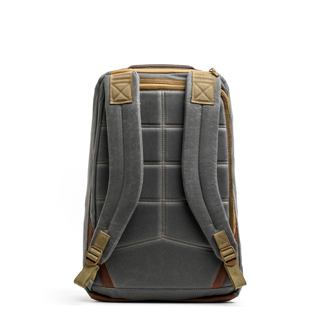 The GORUCK GR1 USA - Heritage is a gray retro canvas rucksack featuring padded straps, brown accents, and a quilted back, made from durable waxed duck canvas.
