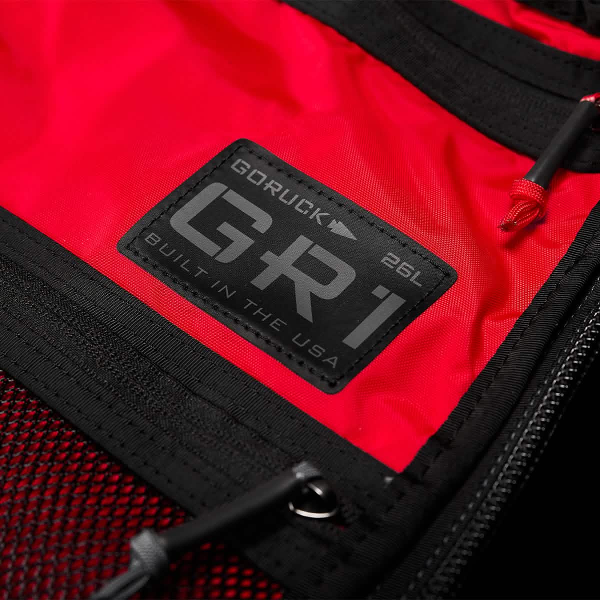 Black and red fabric backpack showcasing AquaGuard zippers and a close-up of the label 