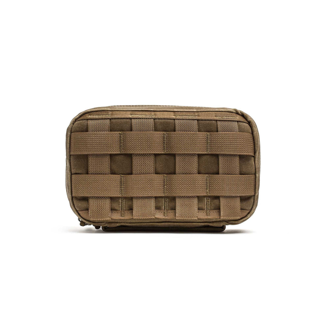 The GR1 Field Pocket - Waxed Canvas is a small brown pouch featuring horizontal webbing detail, displayed against a white background.