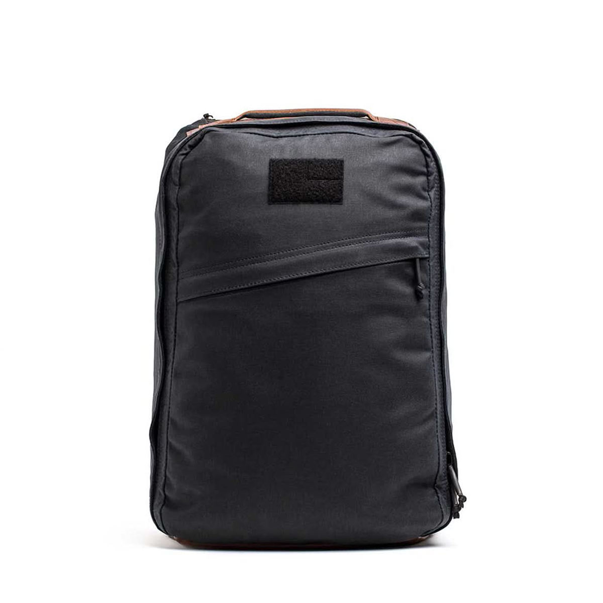 The GR1 USA - Heritage by GORUCK is a sleek black rucksack made from waxed duck canvas, with a front zipper and Red Wing leather accents on the top handle.