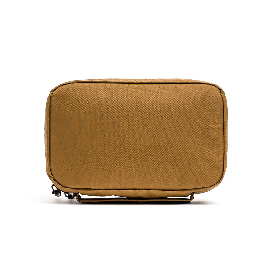The GORUCK GR1 Field Pocket - X-PAC is a tan rectangular pouch with a diamond pattern, made from waterproof fabric and featuring a top zipper.