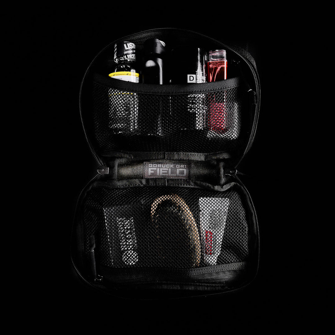 The GORUCK GR1 Field Pocket is a black Cordura zippered pouch with mesh pockets, ideal as a dopp kit for toiletries and grooming essentials, shown against a black background.