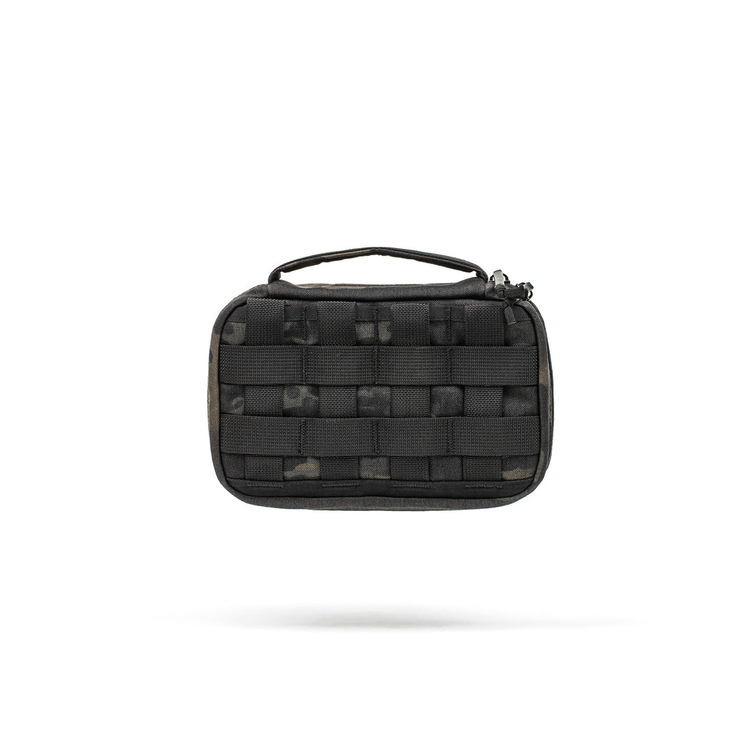 The GORUCK GR1 Field Pocket is a small black tactical pouch with a handle and front woven straps, ideal for organizing electronics, shown isolated on a white background.