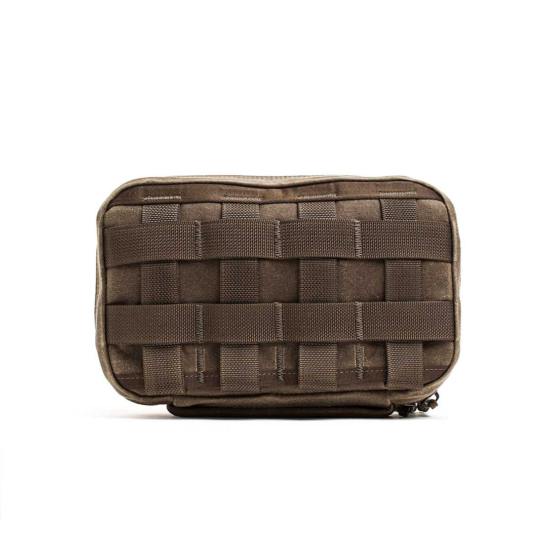 The GORUCK GR1 Field Pocket - Waxed Canvas is a brown tactical pouch with front MOLLE webbing, made from durable waxed duck canvas and shown against a white background.