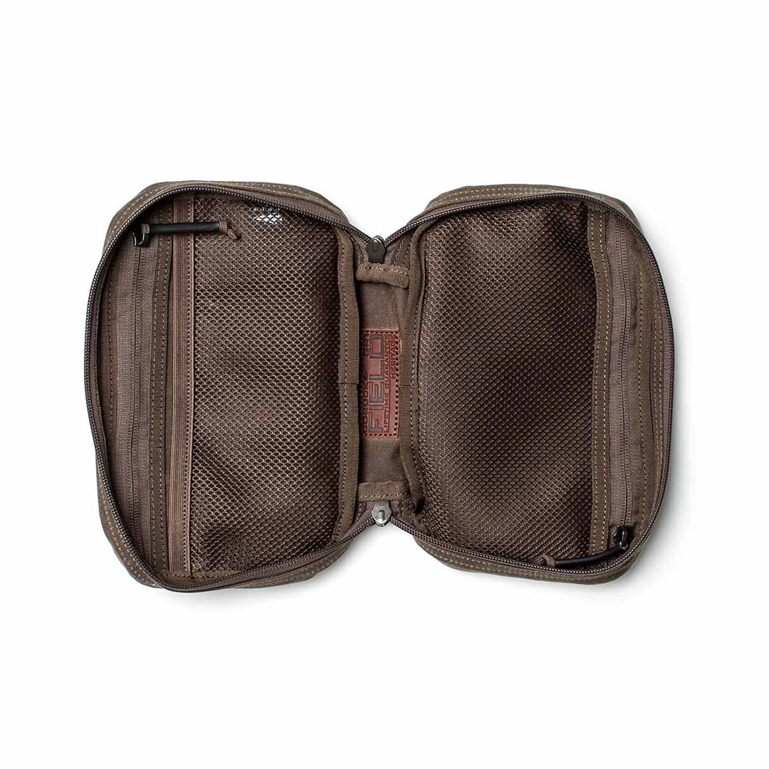 The GORUCK GR1 Field Pocket – Waxed Canvas opens flat to reveal two mesh compartments and an inner fabric label, making it a durable and compact rucksack organizer crafted from Waxed Duck Canvas.