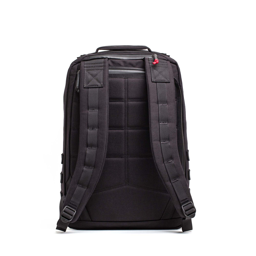 The GORUCK GR2, a rugged black carry-on inspired by Special Forces backpacks, is shown from the back with padded straps and a top zipper pocket.