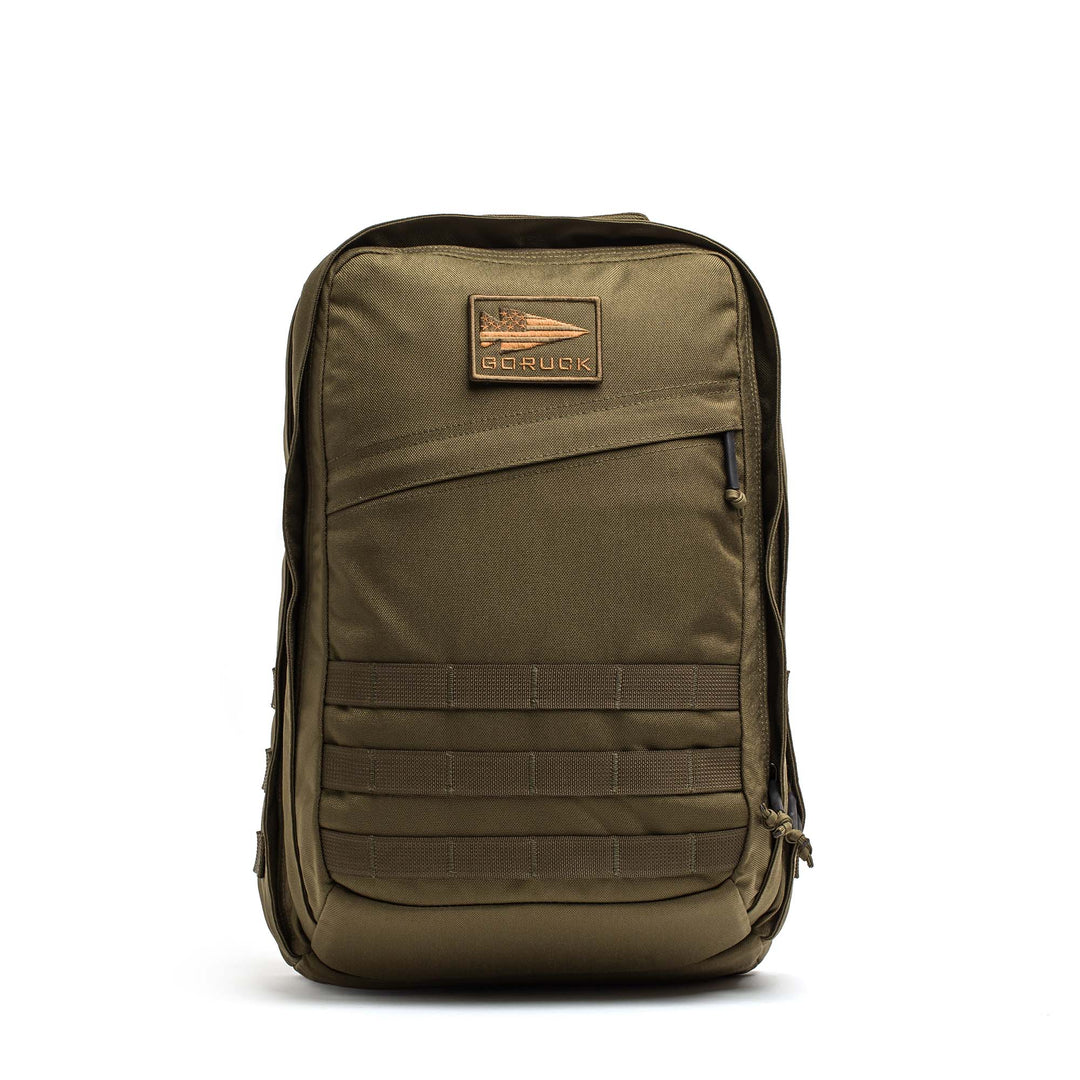 The GORUCK GR2 is an olive green tactical travel backpack inspired by the classic ruck, with multiple zippers, a front patch, and webbing on the lower front panel.
