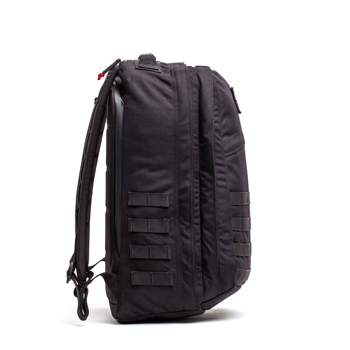 The GORUCK GR2 backpack, shown from the side, features multiple horizontal straps and padded shoulder straps—making it a durable carry-on option for any adventure.