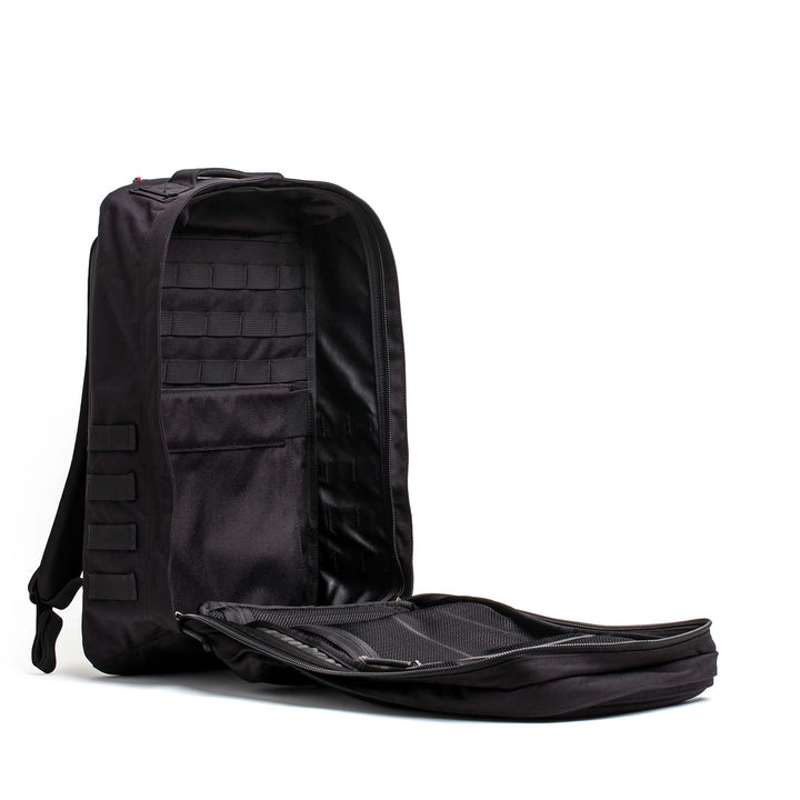 A black GORUCK GR2 ruck with its main compartment unzipped and open, displaying an organized interior.