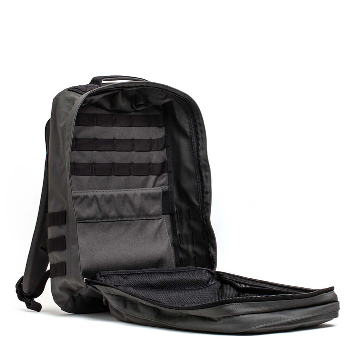 The GORUCK GR2, a black Special Forces backpack, features an open main compartment displaying internal pockets and a mesh organizer—ideal for organized travel.