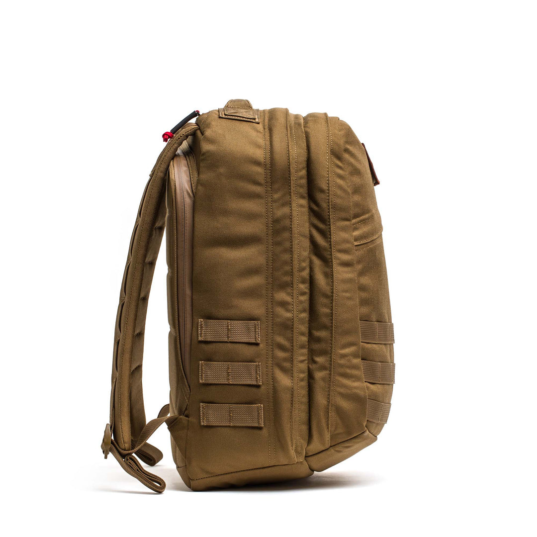 The GORUCK GR2 tan tactical backpack stands upright, shown from the side, with multiple compartments and MOLLE straps—built for reliable Special Forces-style performance.
