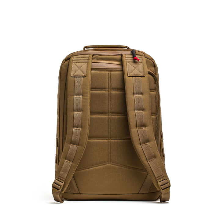 A brown GORUCK GR2 travel backpack shown from the back, featuring padded shoulder straps and a top handle—resembling the classic ruck used by Special Forces.