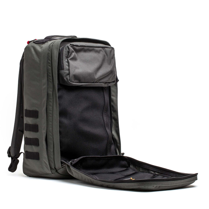The GORUCK GR2 is a gray carry-on backpack shown with its main compartment unzipped, revealing interior pockets and mesh lining.