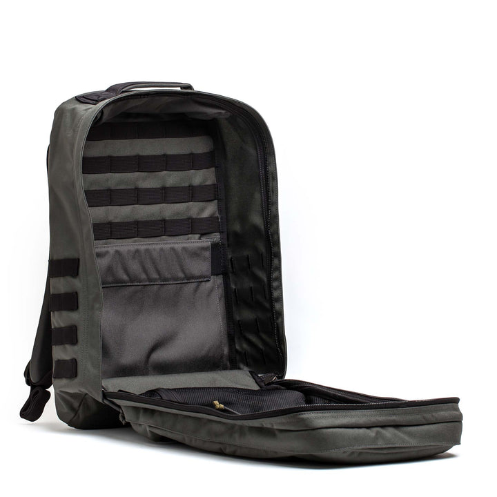 The GORUCK GR2 gray carry-on backpack is open, revealing an empty main compartment with interior pockets and MOLLE webbing.