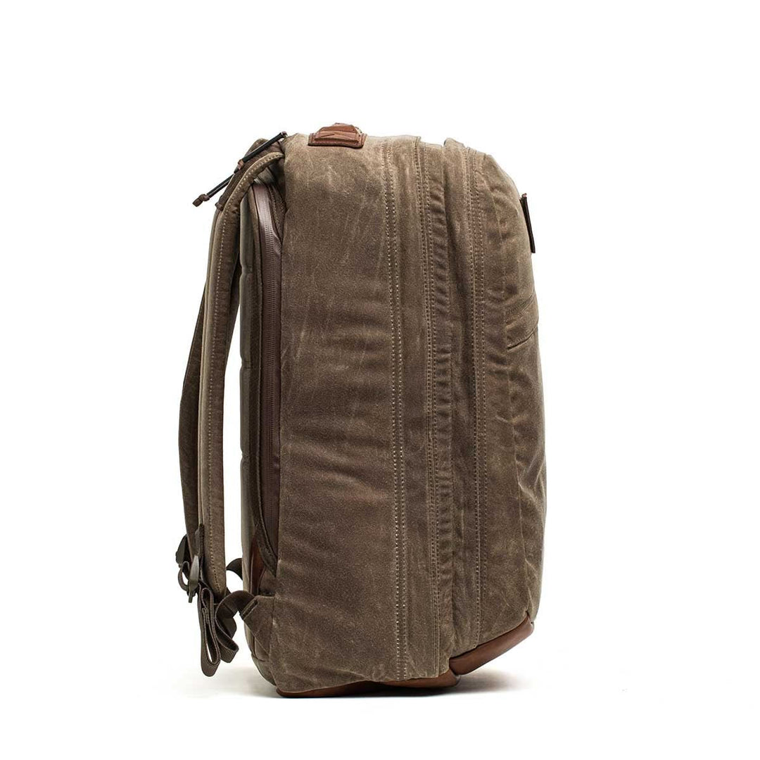 Side view of the GORUCK GR2 - Heritage Waxed Canvas backpack in brown, featuring Red Wing leather details, a bombproof laptop compartment, and adjustable shoulder straps.