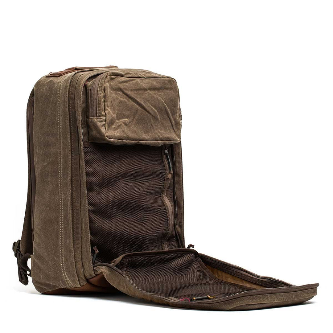 The GORUCK GR2 - Heritage Waxed Canvas is a brown backpack shown upright with its main compartment unzipped, displaying inner mesh pockets and a bombproof laptop compartment for extra protection.