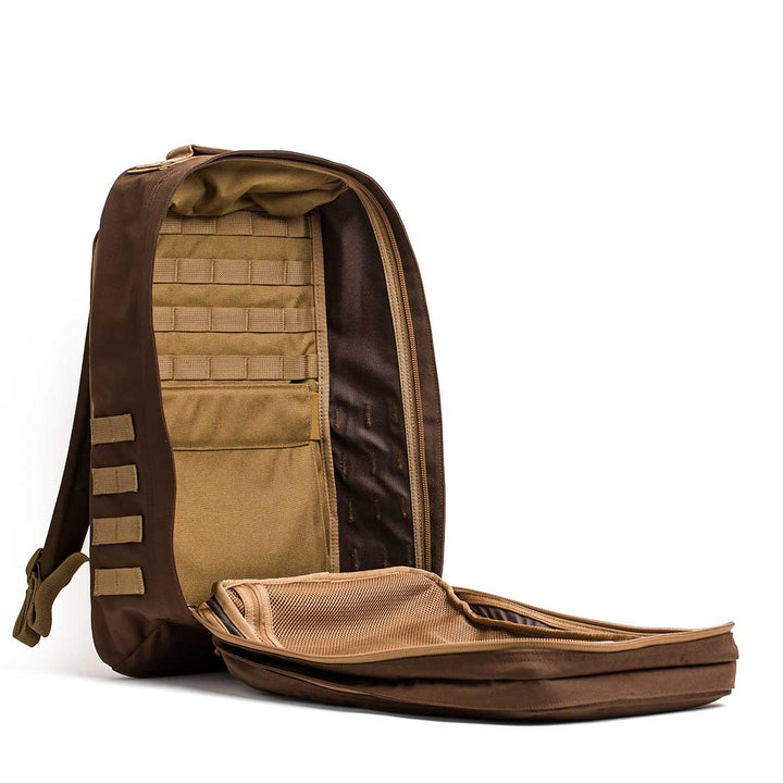The GORUCK GR2 backpack in brown is shown with its main compartment unzipped, displaying interior pockets and mesh organizers.