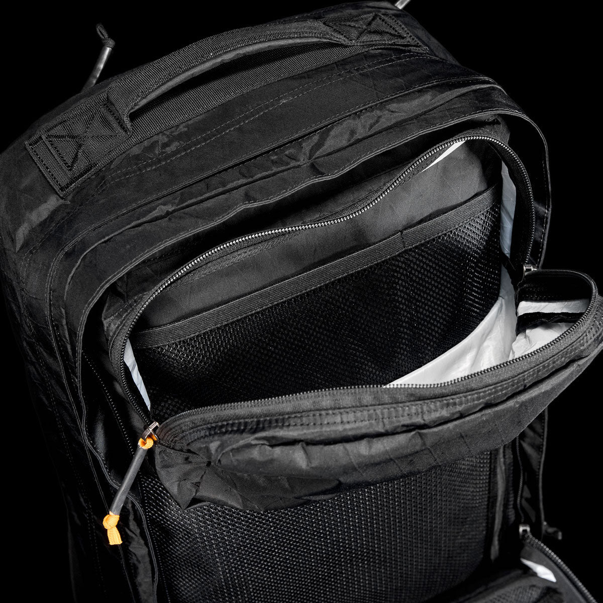 GORUCK black rucksack open, showing multiple zippered compartments and rugged interior design