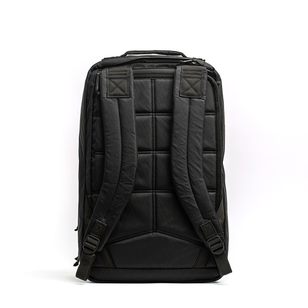 The GORUCK GR2 X-PAC, shown from the back, is a black waterproof backpack with padded shoulder straps, a quilted back panel, and tough X-PAC material for maximum durability.