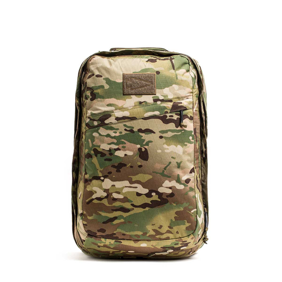 The GORUCK GR2 X-PAC is a camouflage-patterned backpack made from waterproof X-PAC fabric, featuring a front zipper pocket and a rectangular patch on top.