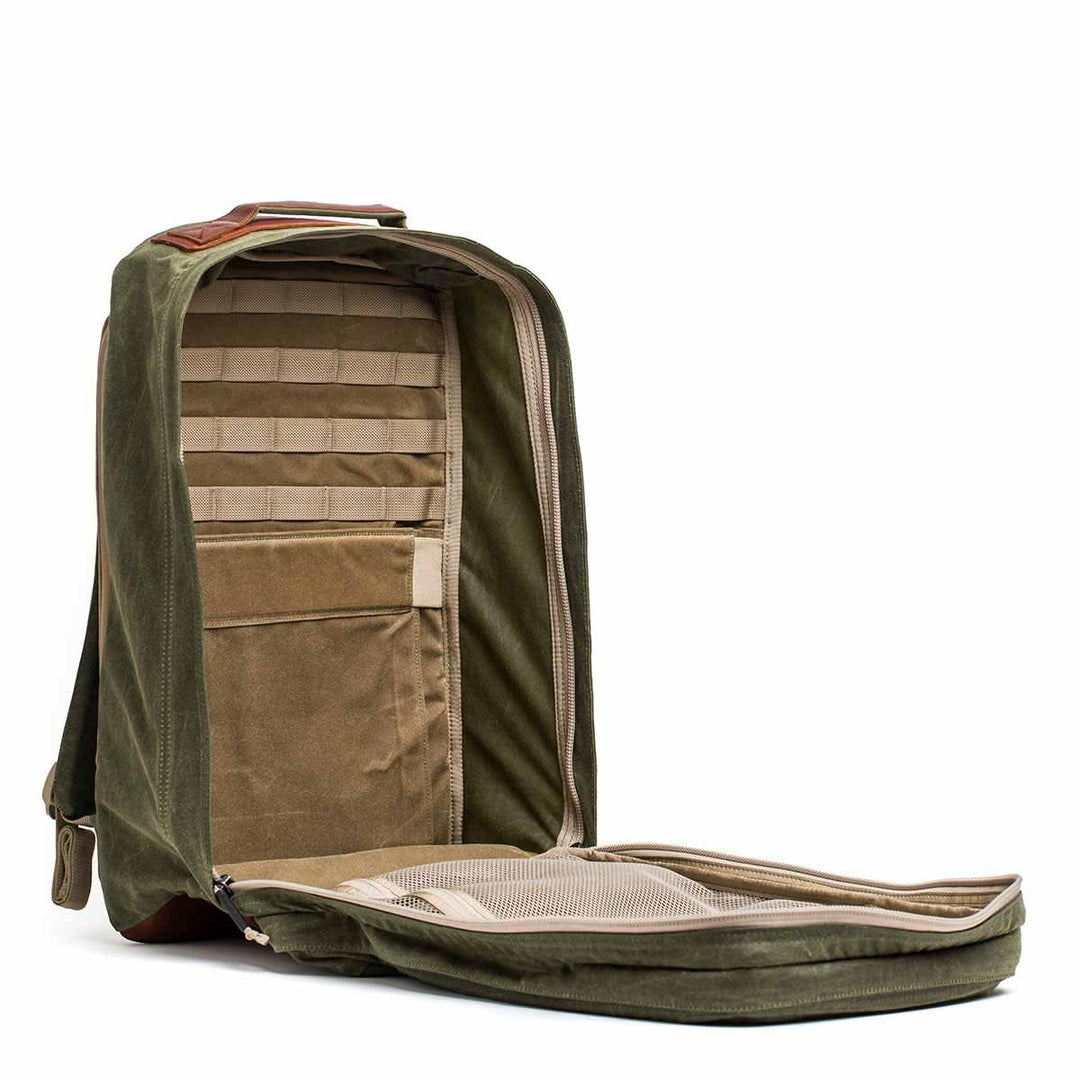 The GORUCK GR2 - Heritage Waxed Canvas is an olive green backpack with a tan interior, Red Wing leather accents, and multiple organizational compartments—ideal for all your travel ruck needs.