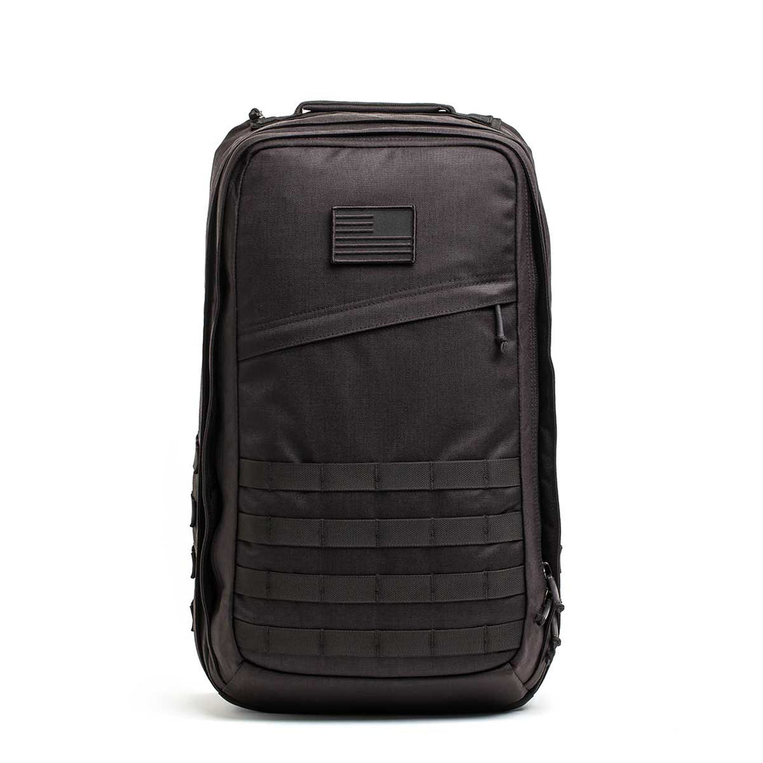 The GORUCK GR2 - USA is a black tactical backpack with an American flag patch and front horizontal webbing—perfect as a ruck or carry-on travel bag.