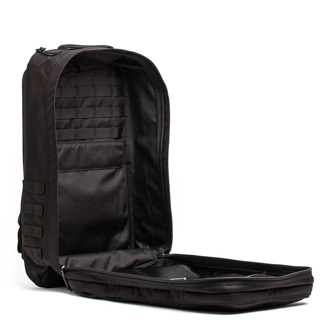 The GORUCK GR2 - USA backpack in black is shown open, featuring multiple interior compartments and a front zippered flap, making it an ideal carry-on travel bag.