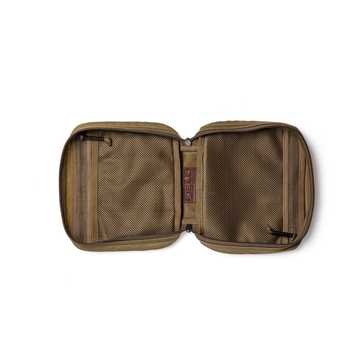 The GORUCK GR2 Field Pocket - Waxed Canvas, a tan zippered pouch inspired by classic field gear, lies open to reveal mesh pockets on both sides for organizing small items, combining rugged durability with timeless style.