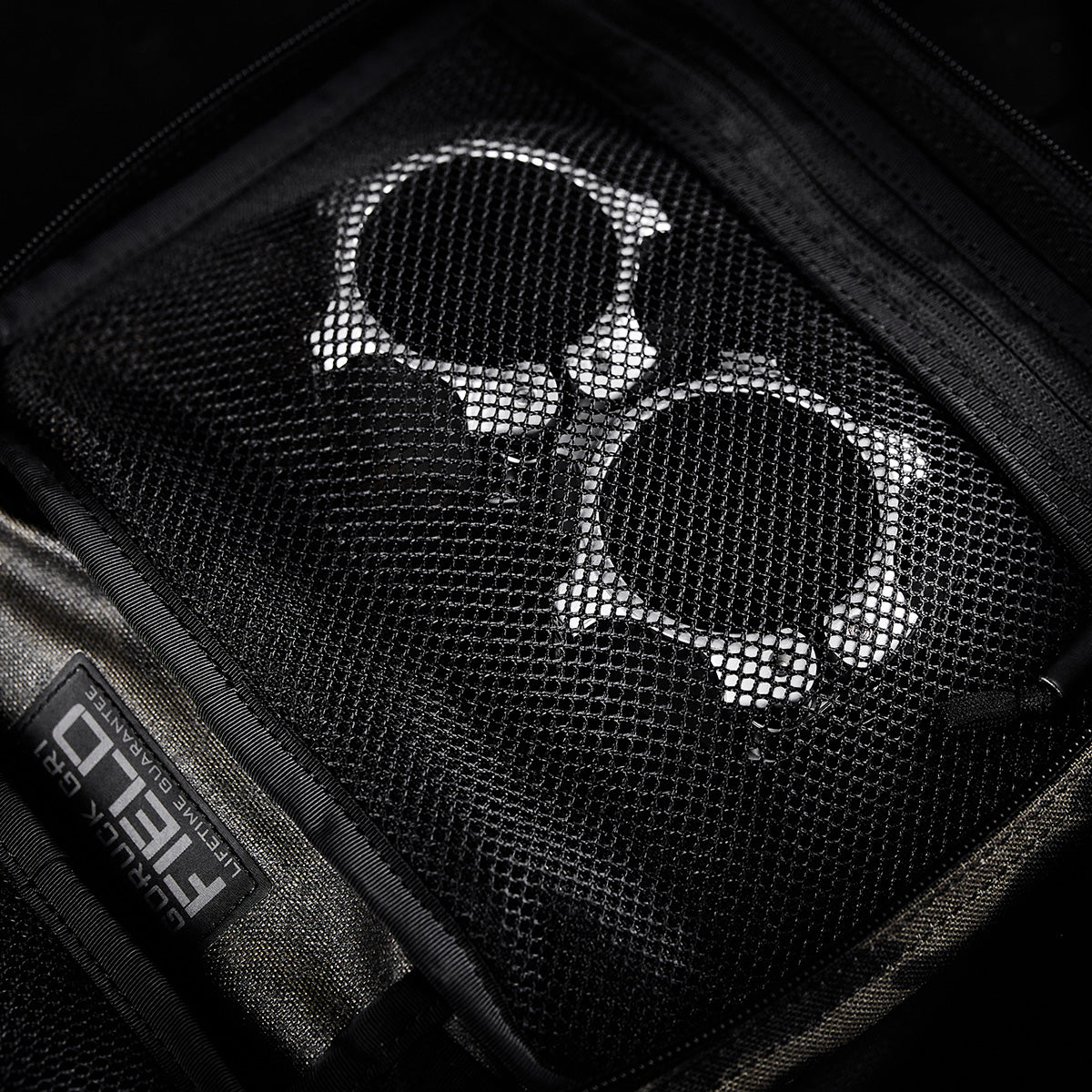 Two metallic handcuffs stored in a zippered mesh pocket inside the GORUCK GR2 Field Pocket, crafted from rugged 1000D Cordura.