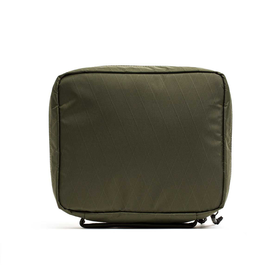 The GORUCK GR2 Field Pocket - X-PAC is a green, rectangular, soft-sided travel packing cube with a bottom handle and zipper, made from waterproof fabric to keep your camera gear or electronics safe and dry.