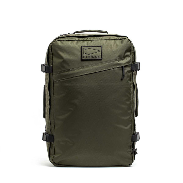 The GR3 - X-PAC is an olive green carry-on backpack featuring black zippers, handles, a front GORUCK logo patch, and waterproof material. Built for durability and covered by the Scars Lifetime Guarantee.