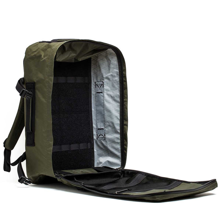 The GR3 - X-PAC is a green carry-on backpack with a fully unzipped main compartment, interior pockets, and light lining—crafted from waterproof material for lasting protection.