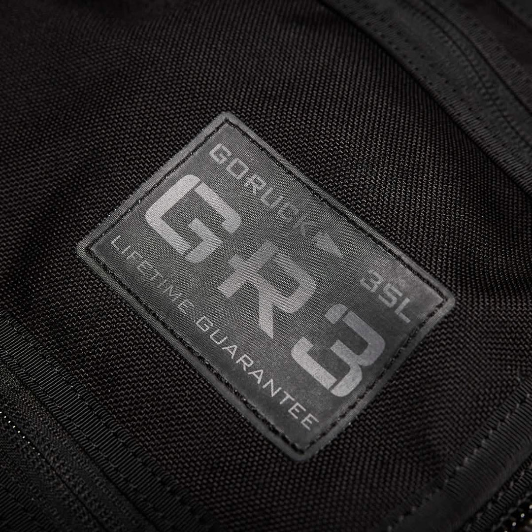 Close-up of a black GORUCK GR3 - Cordura backpack label highlighting its rugged design, waterproof zippers, and "LIFETIME GUARANTEE" badge.