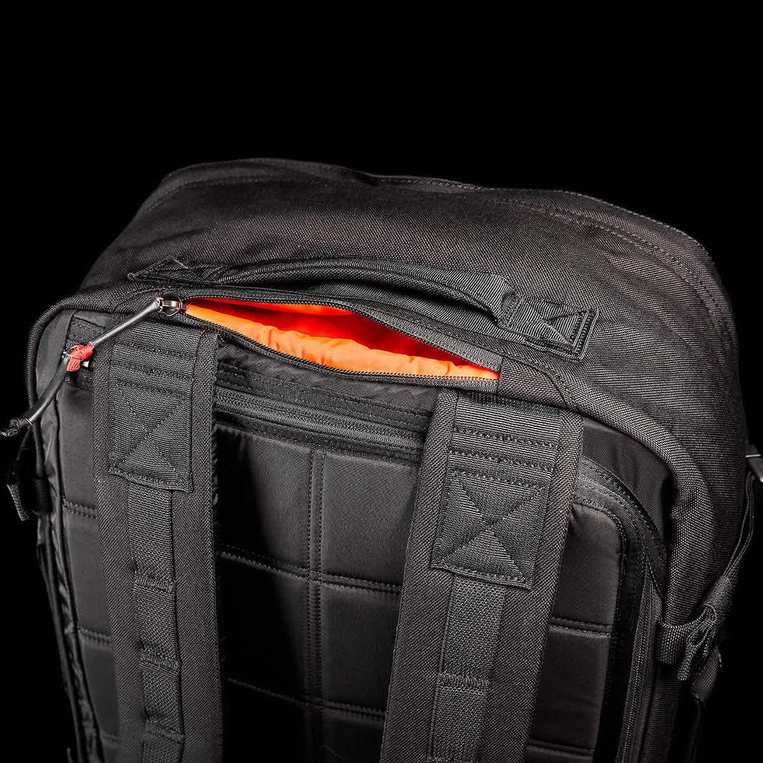 The GORUCK GR3 - Cordura travel backpack features padded straps, waterproof zippers, and an open top pocket with orange lining, displayed against a black background.