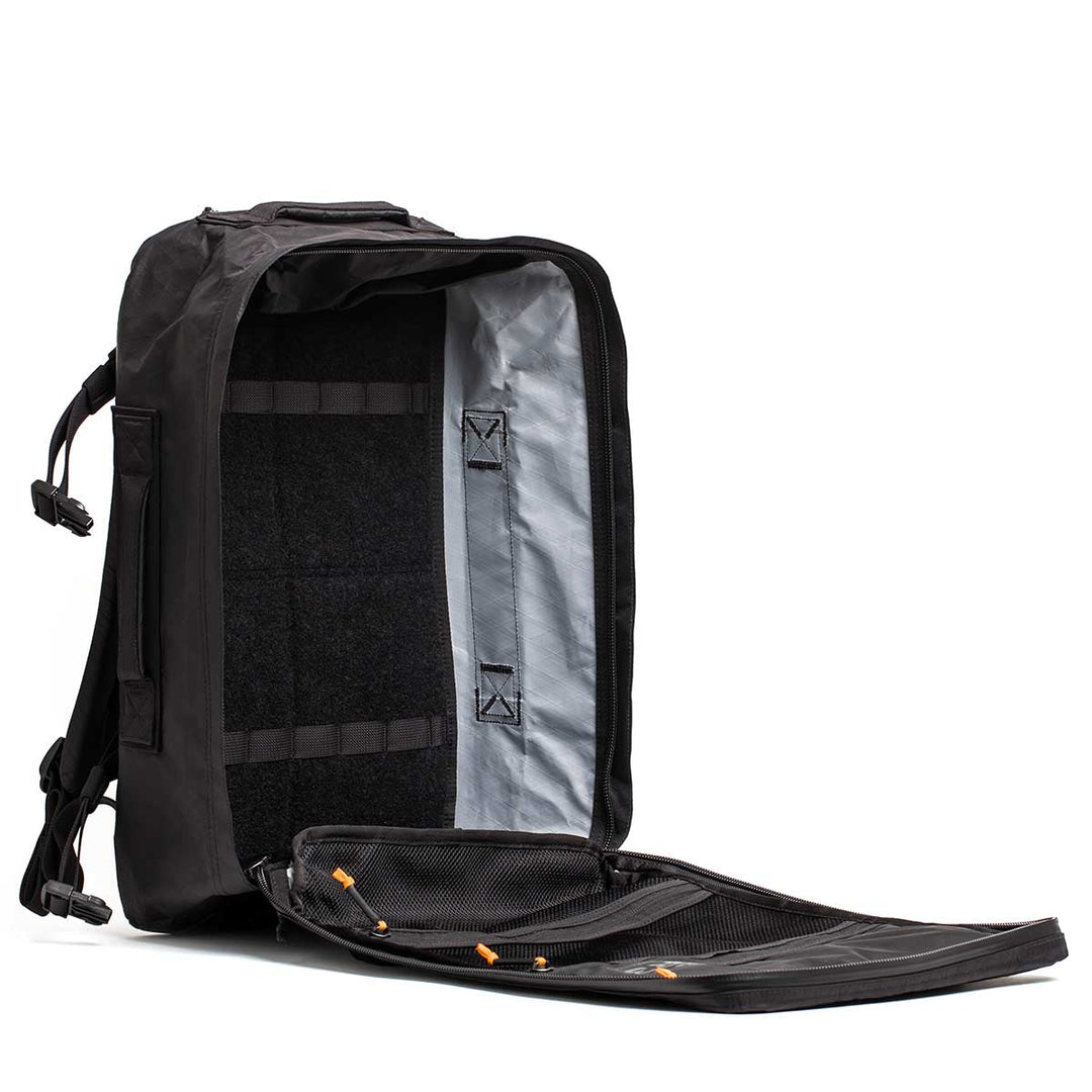The GORUCK GR3 - X-PAC black carry-on backpack is open, revealing a spacious main compartment and a mesh pocket on the flap, all made from ultra-waterproof material.