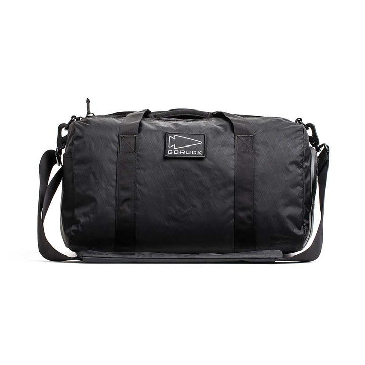 A black Gym Bag - X-PAC featuring handles, a shoulder strap, and a visible GORUCK logo on the front.