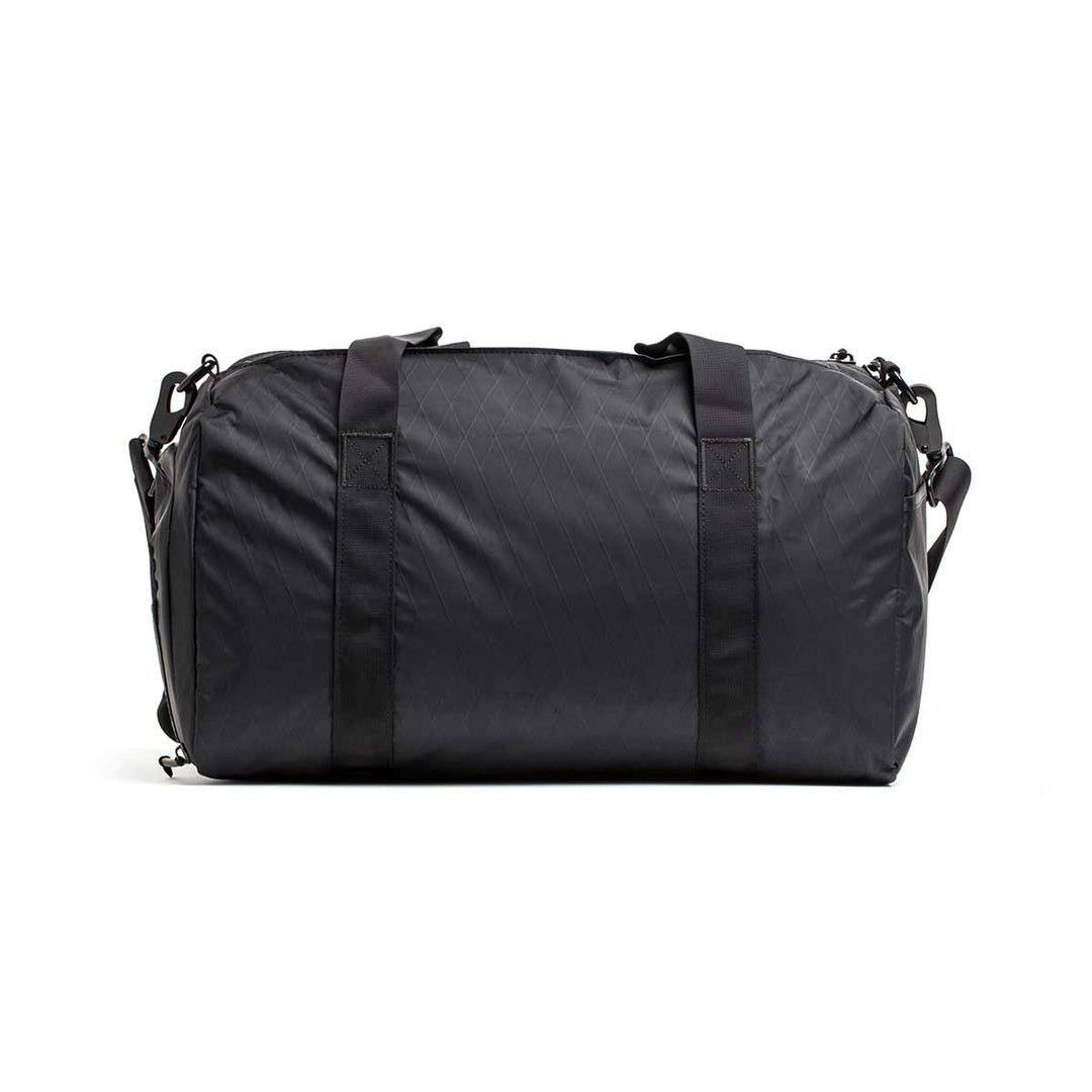The Gym Bag - X-PAC in classic black features two handles and a shoulder strap, shown against a white background.