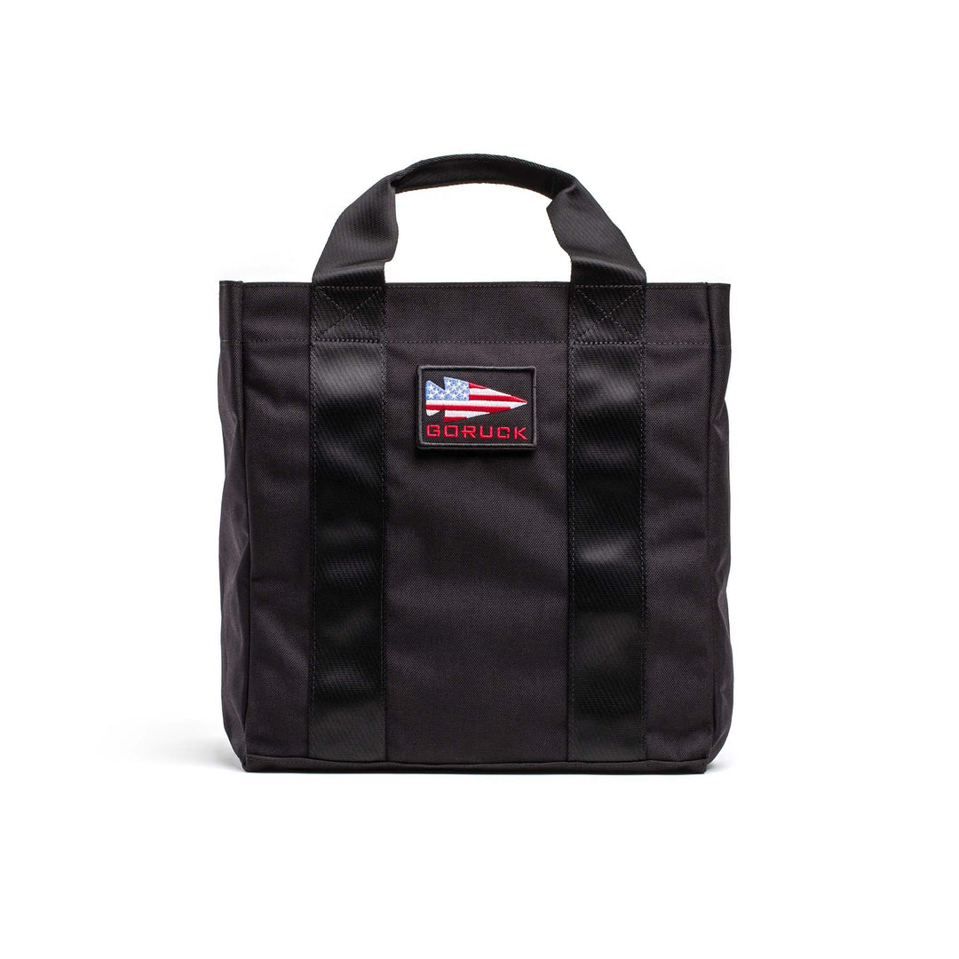 GORUCK black grocery tote bag with American flag patch and sturdy handles on white background