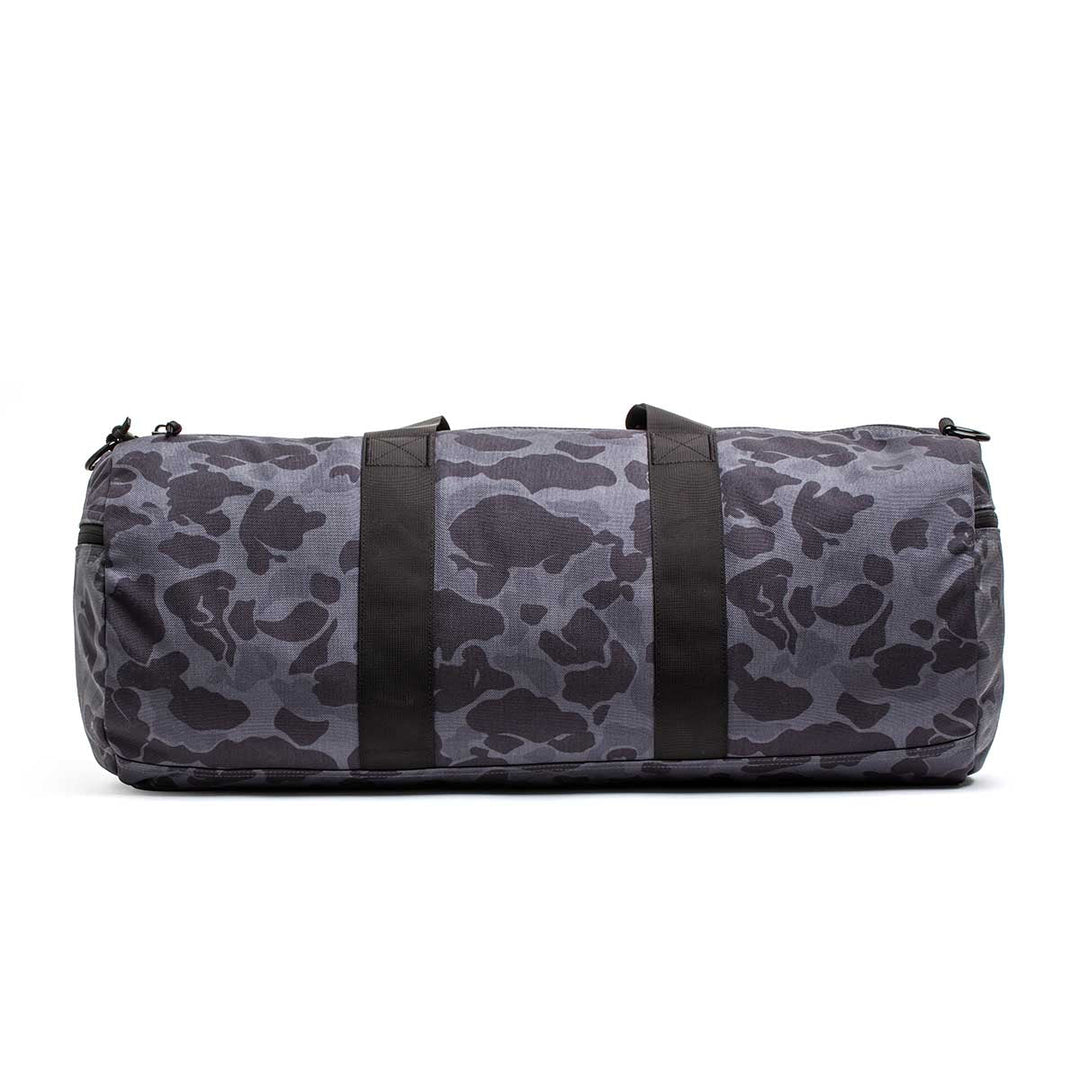The Gym Bag - Cordura is made from durable 1000D CORDURA, showcasing a gray and black camouflage pattern with two black handles, displayed on a white background.