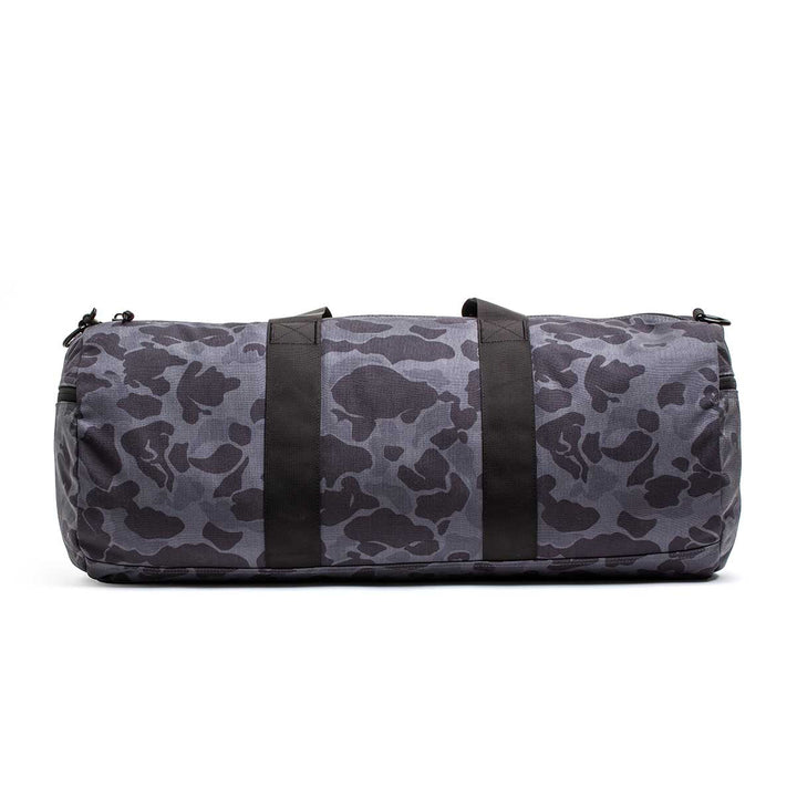 The Gym Bag - Cordura is made from durable 1000D CORDURA, showcasing a gray and black camouflage pattern with two black handles, displayed on a white background.