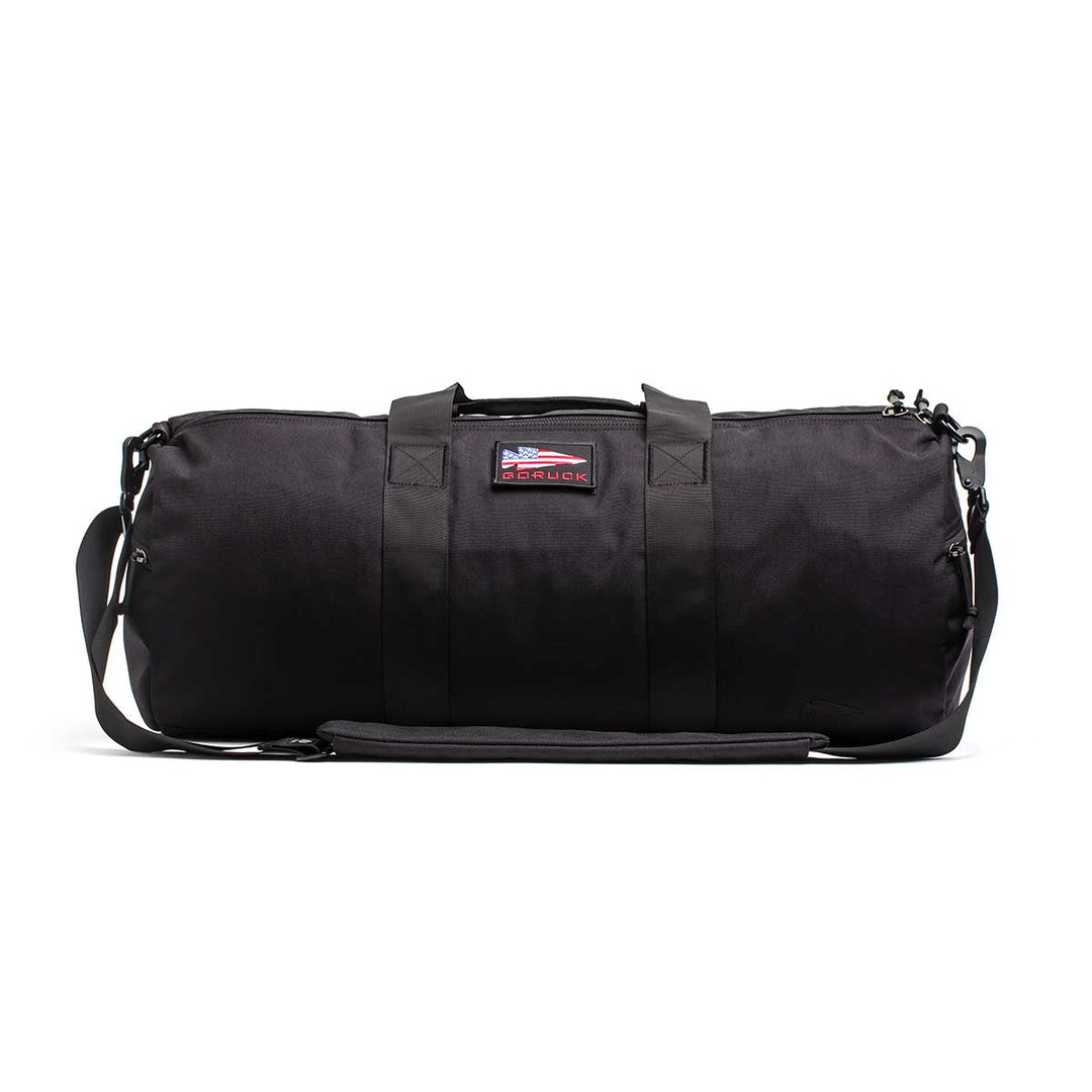 The Gym Bag - Cordura features sturdy handles, a shoulder strap, and an American flag patch. Made from rugged 1000D CORDURA, this bag combines durability and style to carry all your training essentials.