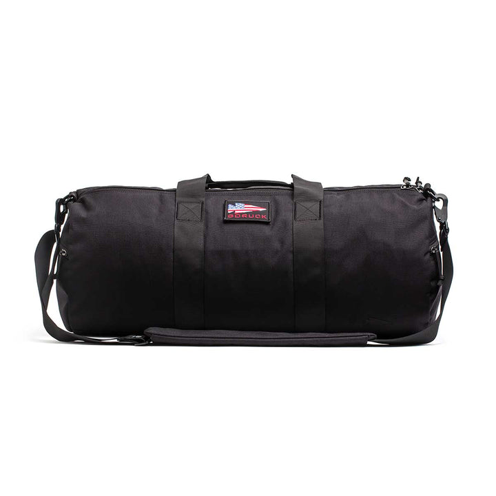 The Gym Bag - Cordura features sturdy handles, a shoulder strap, and an American flag patch. Made from rugged 1000D CORDURA, this bag combines durability and style to carry all your training essentials.