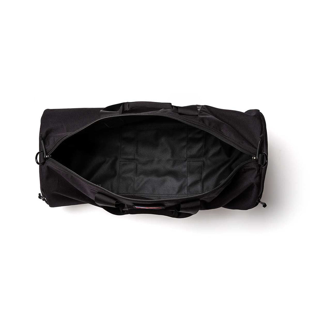 The Gym Bag - Cordura in black, made from durable 1000D CORDURA, is shown from above with its top zipper open, revealing a spacious, empty interior.