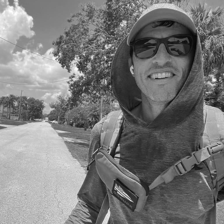 Person wearing GORUCK sternum strap pouch and backpack outdoors, black and white photo.