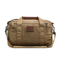 Kit Bag - Waxed Canvas by GORUCK: A tan duffel featuring a shoulder strap, leather accents, front zipper pocket, and a "GORUCK" patch on the front—designed in the classic style of an aviator's kit bag.