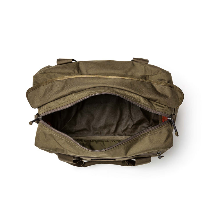 The GORUCK Kit Bag in olive green is shown from above with its main zipper open, displaying its empty interior compartment.