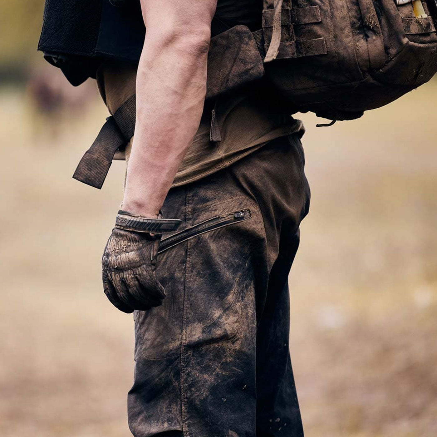 A man wearing dirty pants and a backpack.