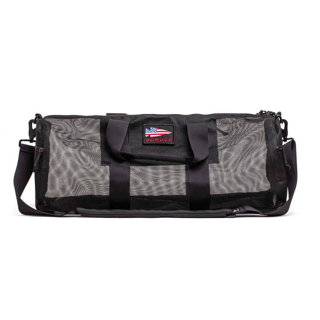 The Mesh Gym Bag is a classic black performance bag with handles, a shoulder strap, and an American flag patch.