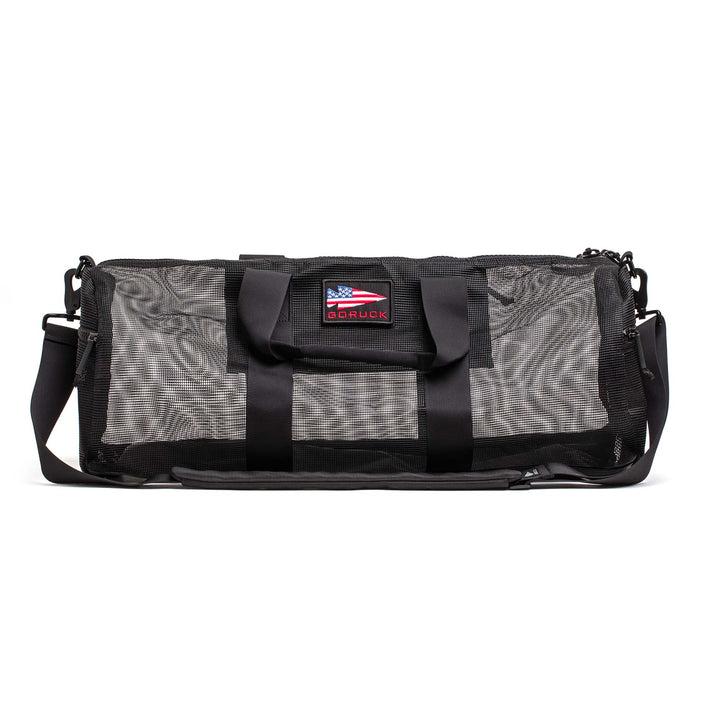 The Mesh Gym Bag is a classic black performance bag with handles, a shoulder strap, and an American flag patch.