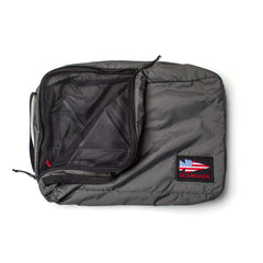 The GORUCK Packing Cubes are gray travel organizers made from durable 200D nylon, featuring a mesh zip pocket for easy organization, an American flag patch, and "GORUCK" text displayed on a white background.